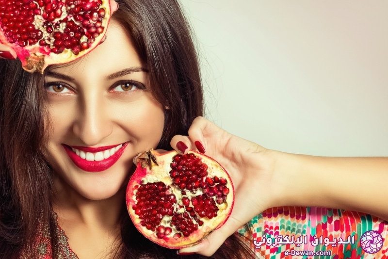 Portrait of a beautiful young woman with a pomegranate